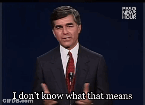 A Man In A Suit And Tie Is Talking Into A Microphone And Says I Don T Know What That Means GIF