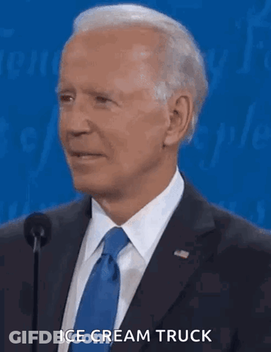 A Man In A Suit And Tie Is Talking Into A Microphone And Says " Ice Cream Truck " GIF