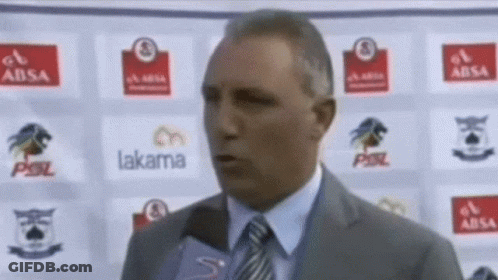 A Man In A Suit And Tie Is Talking Into A Microphone In Front Of A Wall With Logos For Absa Lakama And Psl GIF