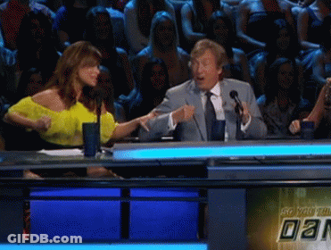 A Man In A Suit And Tie Is Talking Into A Microphone GIF