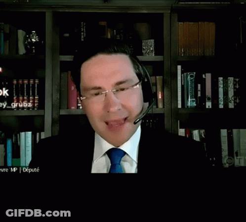 A Man In A Suit And Tie Is Talking Into A Microphone While Looking For A Dollar Figure GIF