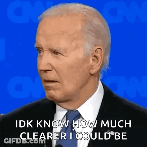 A Man In A Suit And Tie Is Talking Into A Microphone While Making A Funny Face . GIF