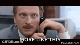 A Man In A Suit And Tie Is Talking On A Cell Phone And Saying `` More Like This '' . GIF