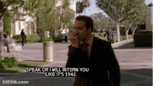 A Man In A Suit And Tie Is Talking On A Cell Phone And Says Speak Or I Will Intern You Like It Is 1942 GIF