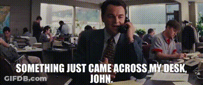 A Man In A Suit And Tie Is Talking On A Cell Phone With The Words Something Just Came Across My Desk John Below Him GIF