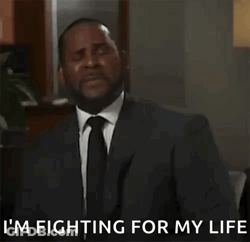 A Man In A Suit And Tie Is Talking On A Cell Phone . GIF