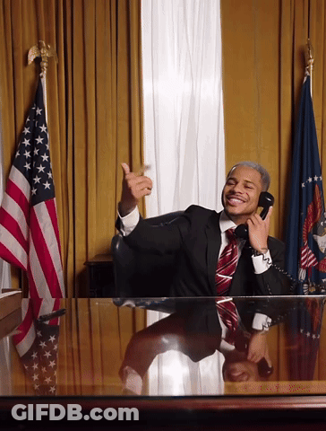A Man In A Suit And Tie Is Talking On A Phone GIF