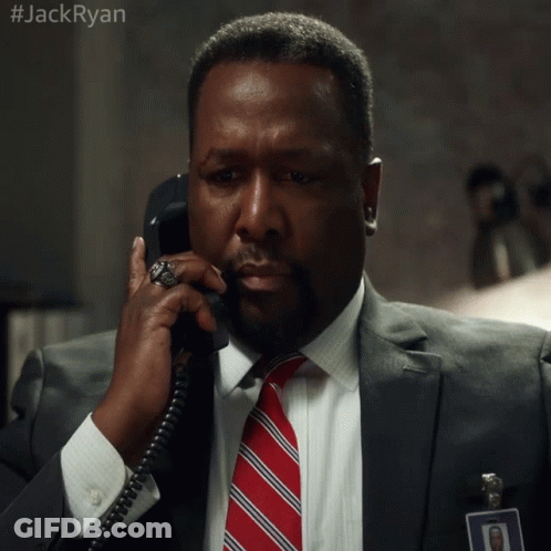 A Man In A Suit And Tie Is Talking On A Phone With #Jackryan Written On The Bottom GIF
