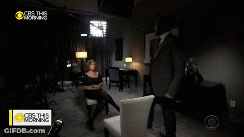 A Man In A Suit And Tie Is Talking To A Woman In A Chair On Cbs This Morning GIF