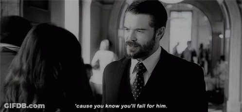 A Man In A Suit And Tie Is Talking To A Woman In A Hallway In A Black And White Photo . GIF