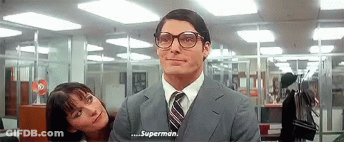 A Man In A Suit And Tie Is Talking To A Woman In An Office Who Is Looking At Him . GIF