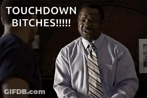 A Man In A Suit And Tie Is Talking To Another Man And Says Touchdown Bitches . GIF