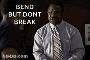 A Man In A Suit And Tie Is Talking To Another Man In A Dark Room . GIF