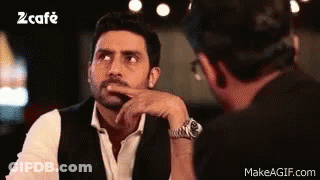 A Man In A Suit And Tie Is Talking To Another Man In A Restaurant . GIF