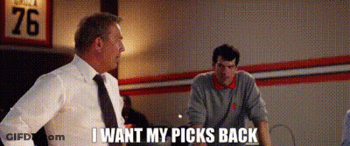 A Man In A Suit And Tie Is Talking To Another Man In A Room While Another Man Looks On . GIF