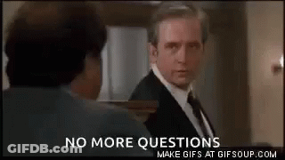 A Man In A Suit And Tie Is Talking To Another Man In A Room With The Words `` No More Questions '' . GIF