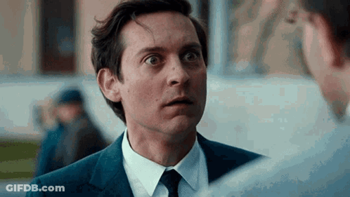 A Man In A Suit And Tie Is Talking To Another Man In A White Shirt . GIF