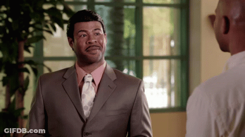 A Man In A Suit And Tie Is Talking To Another Man In A White Shirt GIF