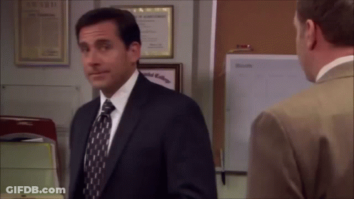 A Man In A Suit And Tie Is Talking To Another Man In An Office . GIF