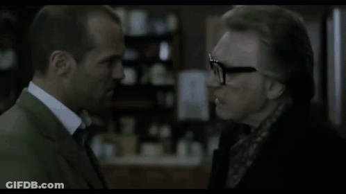 A Man In A Suit And Tie Is Talking To Another Man . GIF