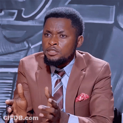 A Man In A Suit And Tie Is Talking With His Hands Outstretched GIF