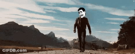 A Man In A Suit And Tie Is Walking Down A Dirt Road . GIF