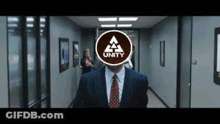 A Man In A Suit And Tie Is Walking Down A Hallway With The Word Unity On His Face GIF