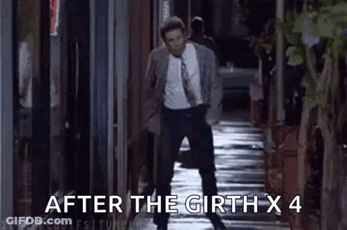 A Man In A Suit And Tie Is Walking Down A Sidewalk At Night . GIF