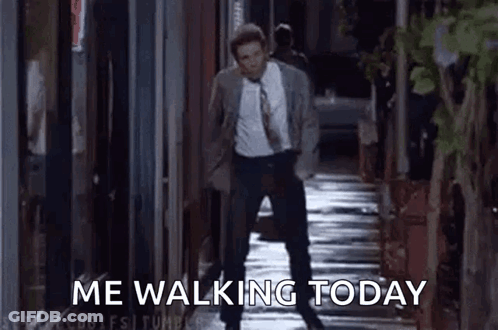 A Man In A Suit And Tie Is Walking Down A Sidewalk With The Words `` Me Walking Today '' . GIF