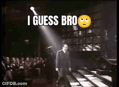 A Man In A Suit And Tie Is Walking Down A Staircase In Front Of A Crowd Of People . GIF