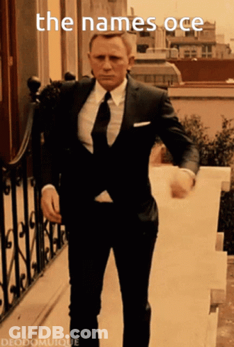 A Man In A Suit And Tie Is Walking Down Stairs With The Words The Names Oce Written Above Him GIF