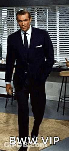 A Man In A Suit And Tie Is Walking With His Hands In His Pockets And The Caption Bww Vip GIF