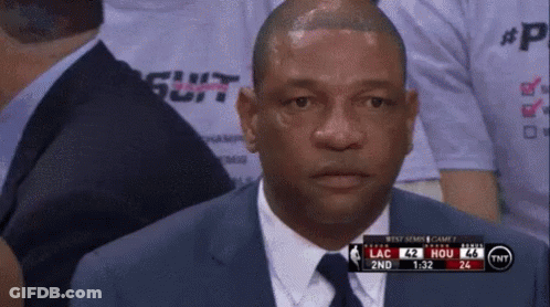 A Man In A Suit And Tie Is Watching A Basketball Game On Tv GIF