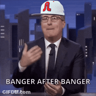 A Man In A Suit And Tie Is Wearing A Baseball Cap That Says R On It GIF