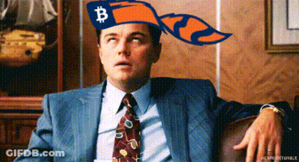 A Man In A Suit And Tie Is Wearing A Hat With A Bitcoin On It . GIF