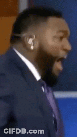 A Man In A Suit And Tie Is Wearing A Headset And Making A Funny Face GIF