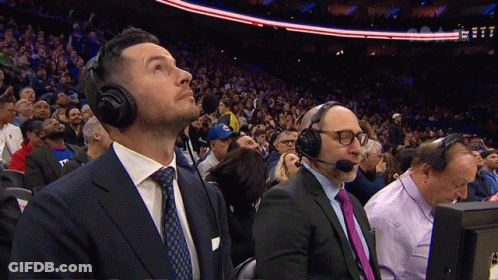 A Man In A Suit And Tie Is Wearing A Headset GIF
