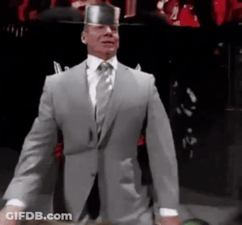 A Man In A Suit And Tie Is Wearing A Knight 'S Hat . GIF