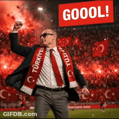 A Man In A Suit And Tie Is Wearing A Scarf That Says Turkey GIF