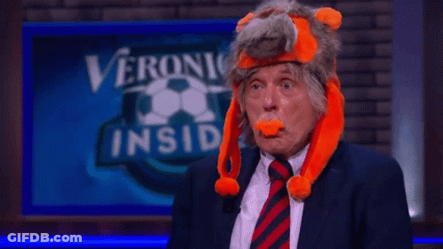 A Man In A Suit And Tie Is Wearing A Stuffed Animal Hat GIF