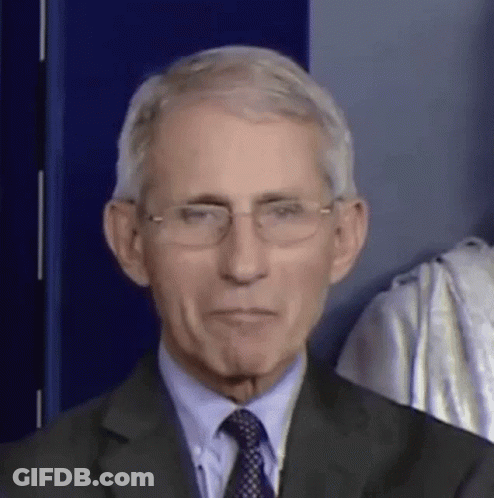 A Man In A Suit And Tie Is Wearing Glasses And Making A Funny Face . GIF