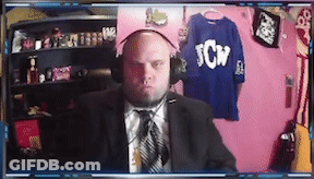 A Man In A Suit And Tie Is Wearing Headphones And A Shirt That Says Tcw On It GIF