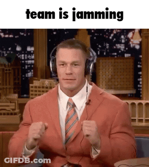 A Man In A Suit And Tie Is Wearing Headphones And Making A Fist In The Air . GIF