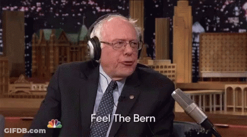 A Man In A Suit And Tie Is Wearing Headphones And Saying Feel The Bern GIF