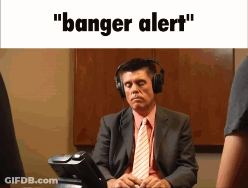 A Man In A Suit And Tie Is Wearing Headphones And The Words " Banger Alert " Are Displayed Above Him GIF