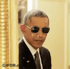A Man In A Suit And Tie Is Wearing Sunglasses GIF