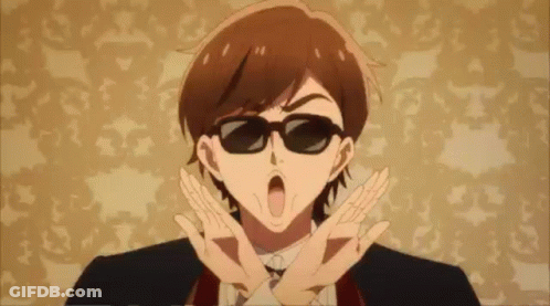 A Man In A Suit And Tie Is Wearing Sunglasses And Making A Peace Sign . GIF