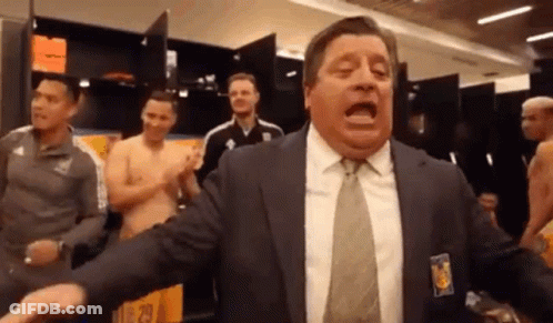 A Man In A Suit And Tie Is Yelling In A Locker Room . GIF