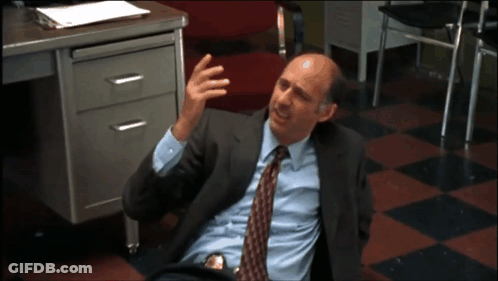 A Man In A Suit And Tie Laying On The Floor GIF