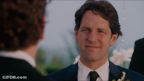 A Man In A Suit And Tie Looks At Another Man In A Black Suit GIF